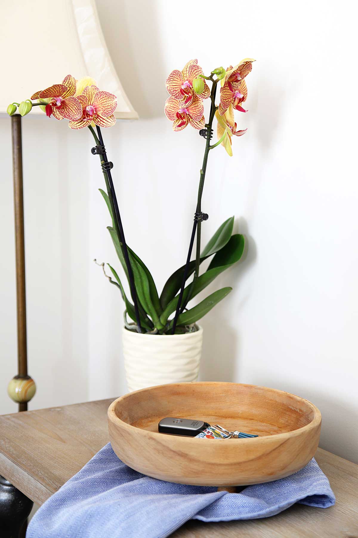Bleached wooden bowl for farmhouse style sitting on counter with orchids