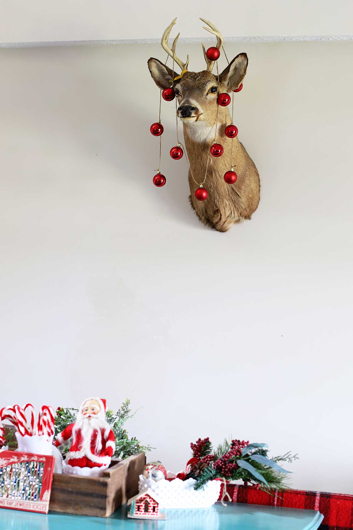 mounted deer head decorated for Christmas with round Christmas ornaments