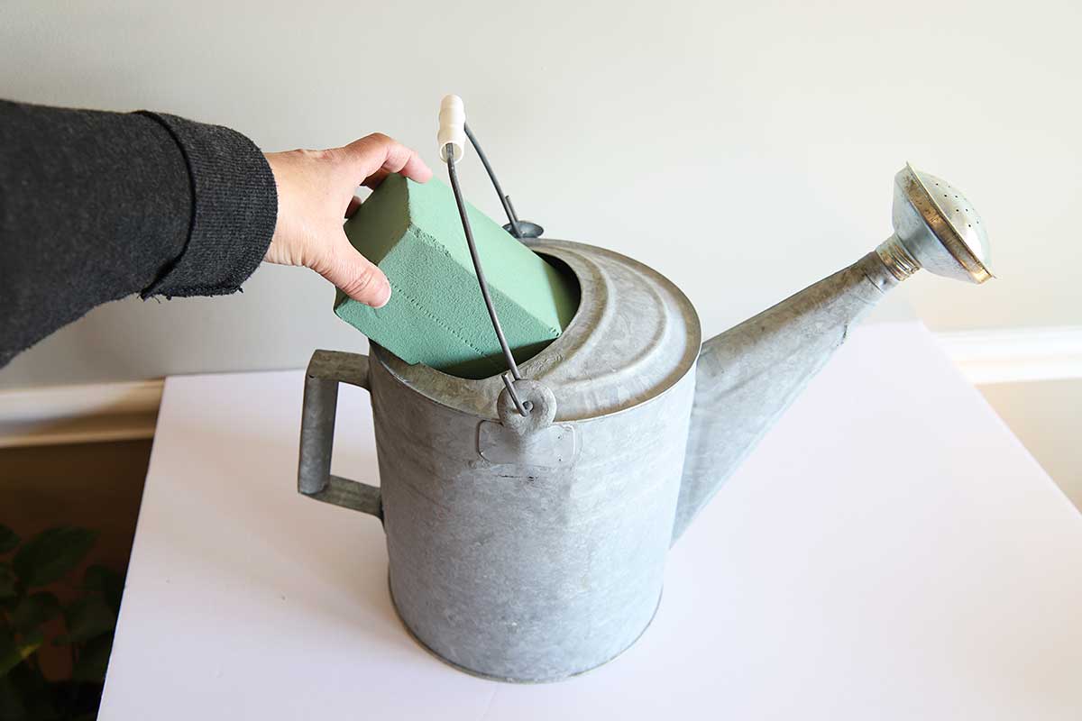 Adding floral foam to watering can