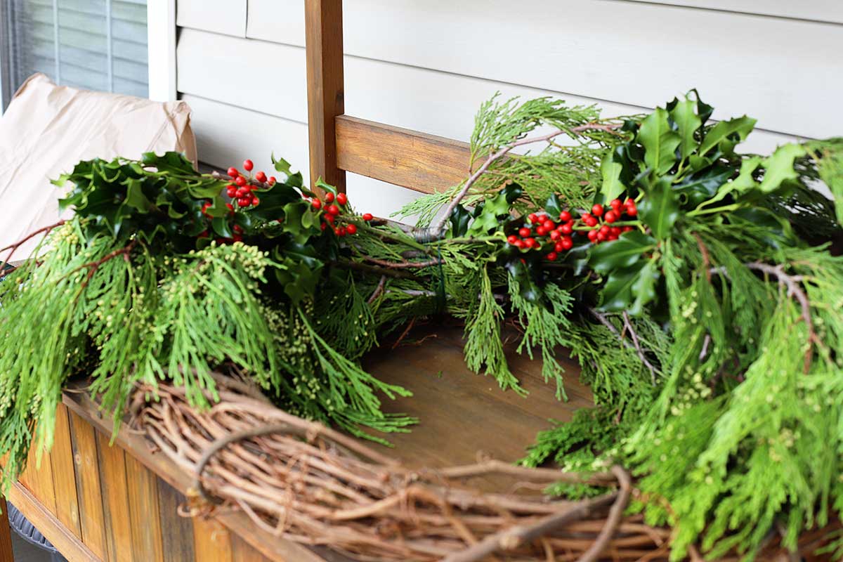 adding holly to evergreen wreath