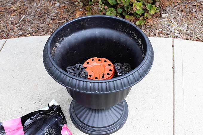 Filling urn with potting soil.