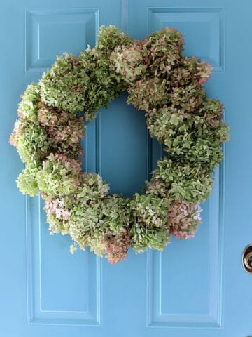 Beautiful hydrangea wreath on blue front door.