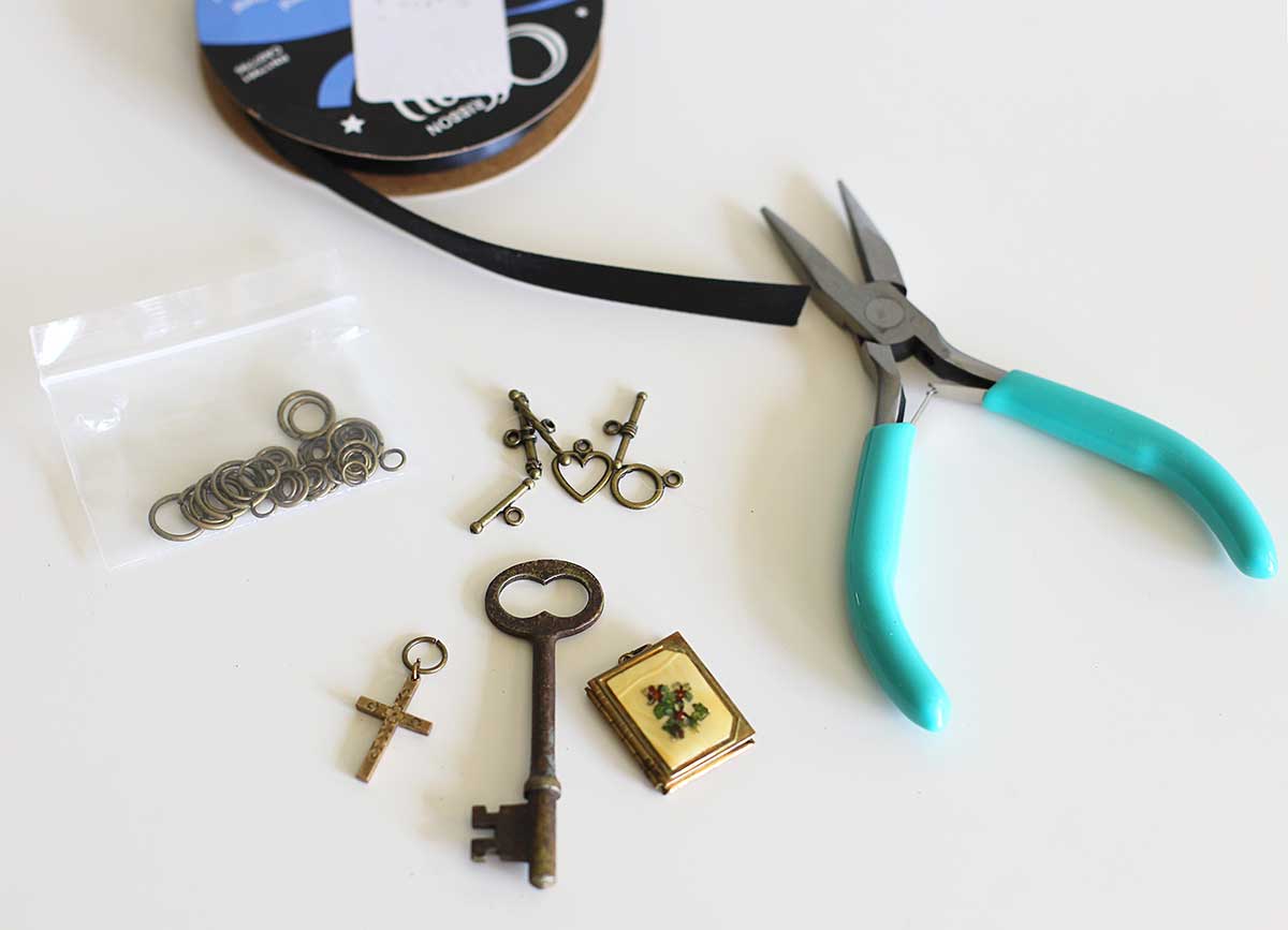 Items used in making jewelry - skeleton key, needle nose plyers, ribbon, jump rings and toggle clasps.