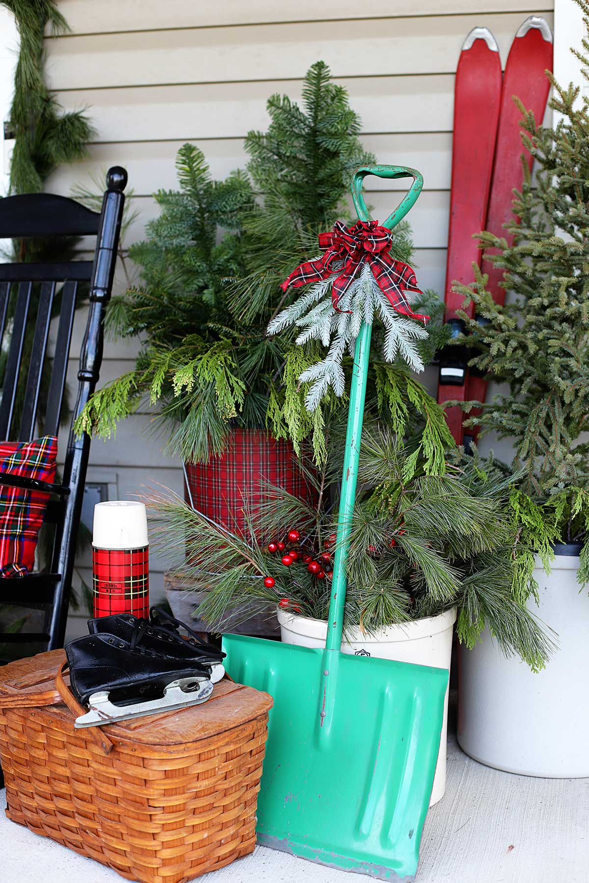 vintage skates, snow shovel and picnic basket on porch for Christmas decor