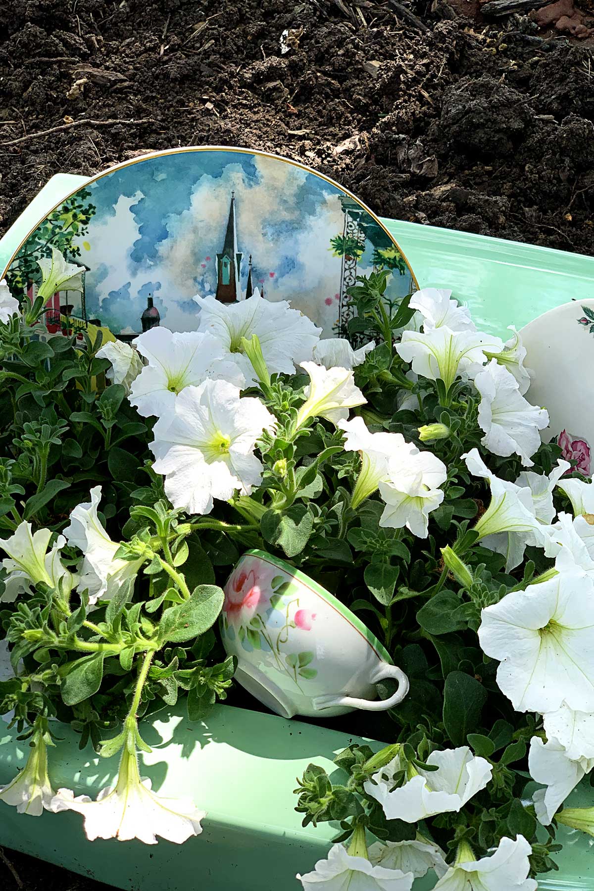 dishes and flower soap bubbles in repurposed sink turned into garden planter