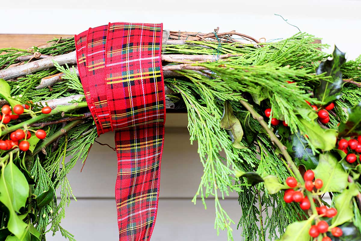 wrapping ribbon around evergreen wreath