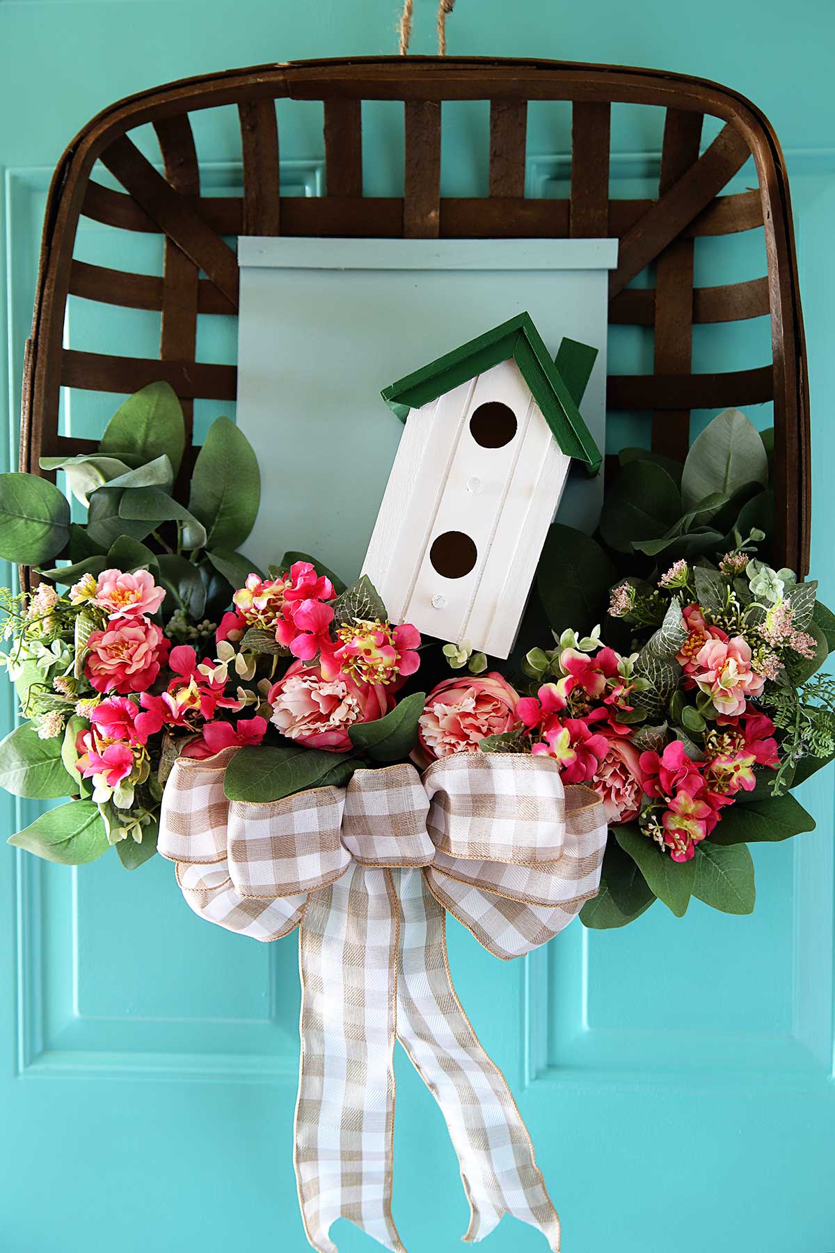 upcycled spring wreath hanging on aqua front door