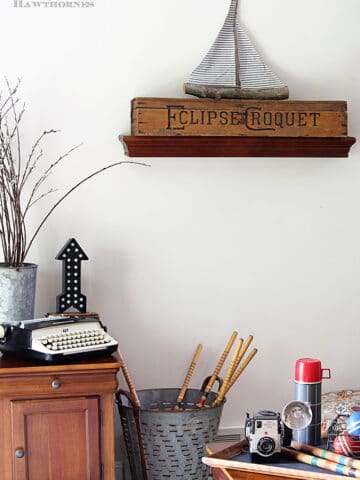 A rustic vintage eclectic style summer home decor tour including vintage thermoses, cameras, typewriter and vintage croquet and badminton equipment.