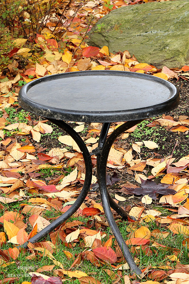 Vintage black metal table that is part of a motel chair set