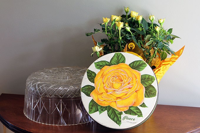 Vintage rose candy tin and mid-century plastic cake cover - could be lucite or acrylic