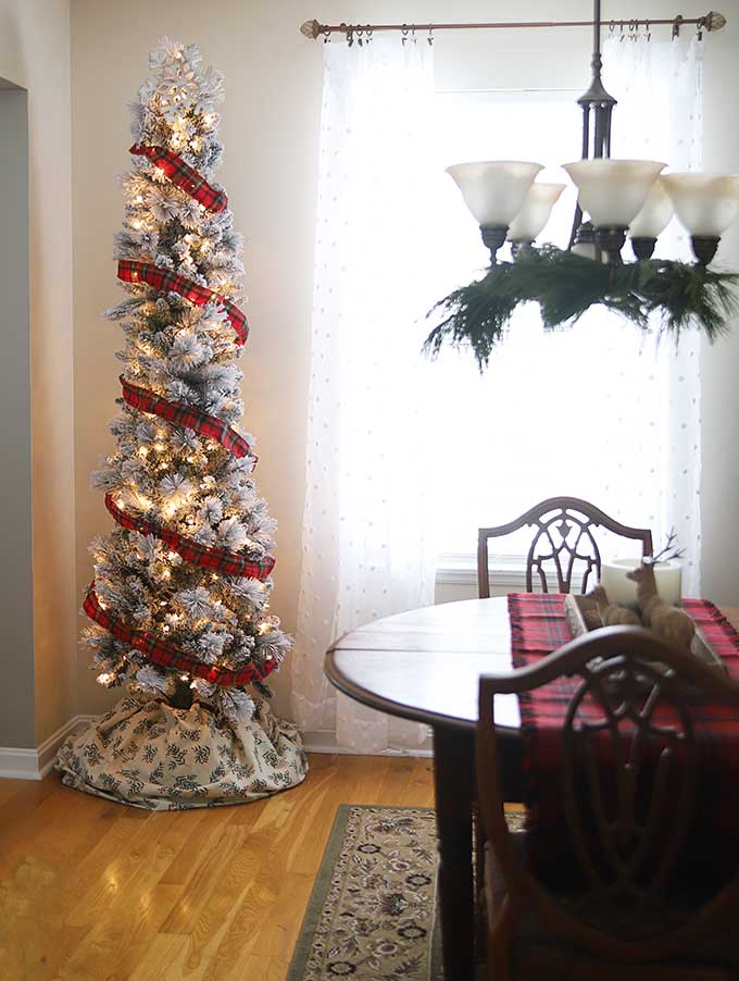 Skinny flocked tree in a vintage rustic Christmas dining room